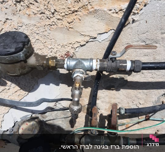 צינורות מים וברזים על קיר חיצוני